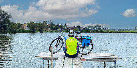 Radler in Yogapose vor der Altmühl